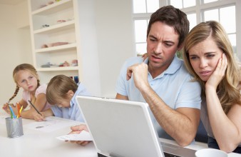 Junges Paar am Laptop, Kinder im Hintergrund